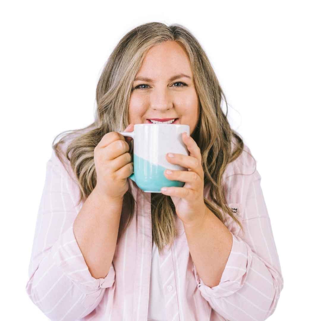 Jessica Chambers of Enlifen Co. smiling while holding a coffee mug close to her face.