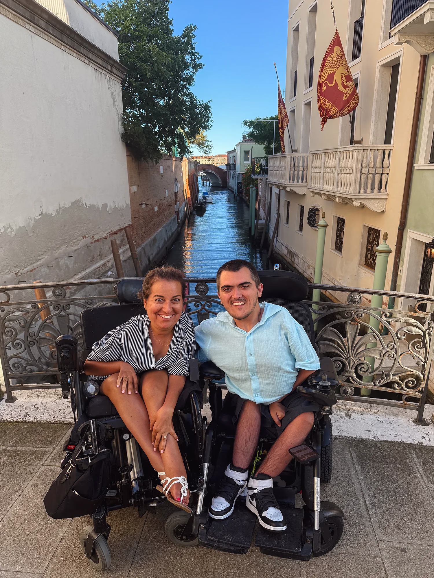 A couple smiling on a bridge in Venice with a canal in the background