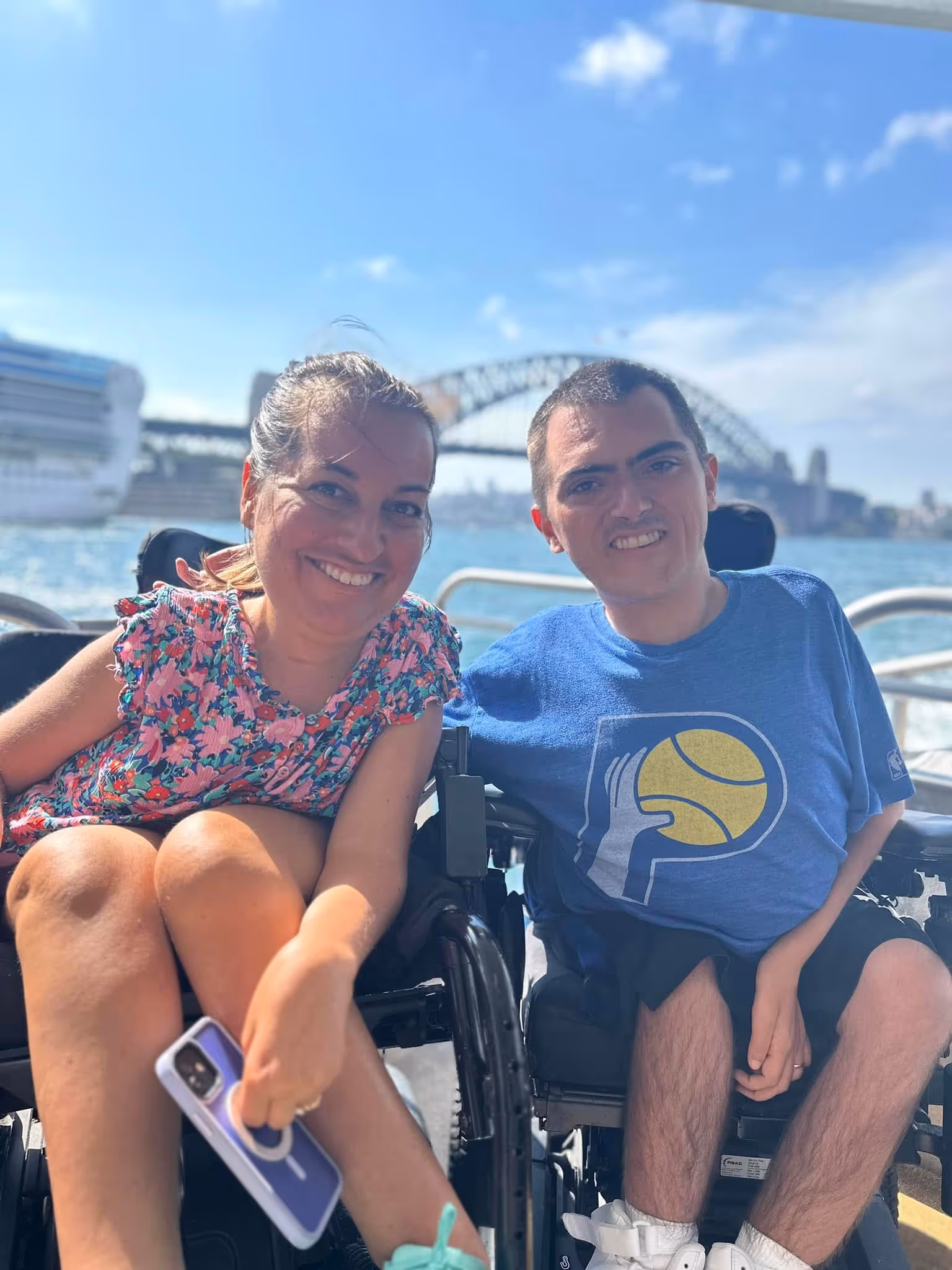 Natalie and Jordan Dickey in Australia with a bridge in the background. They are on a boat