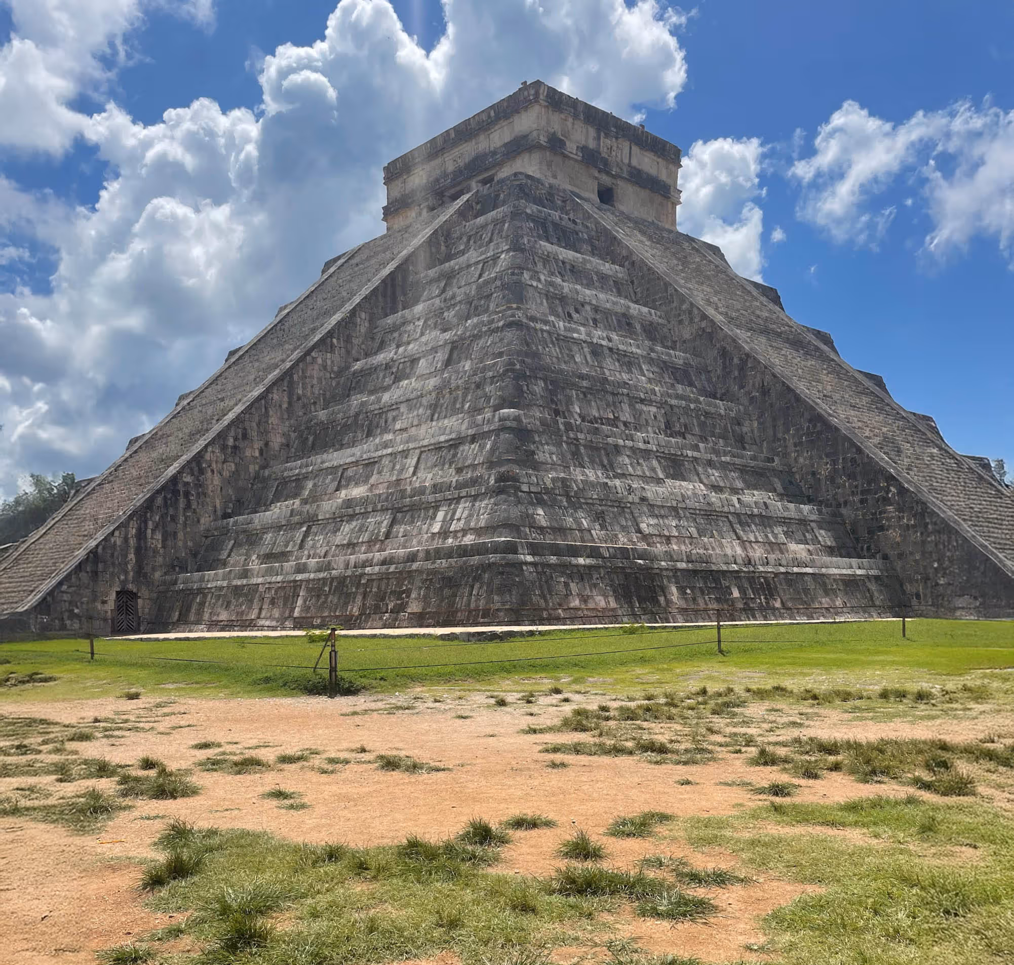 A large pyramid in the middle of a field.