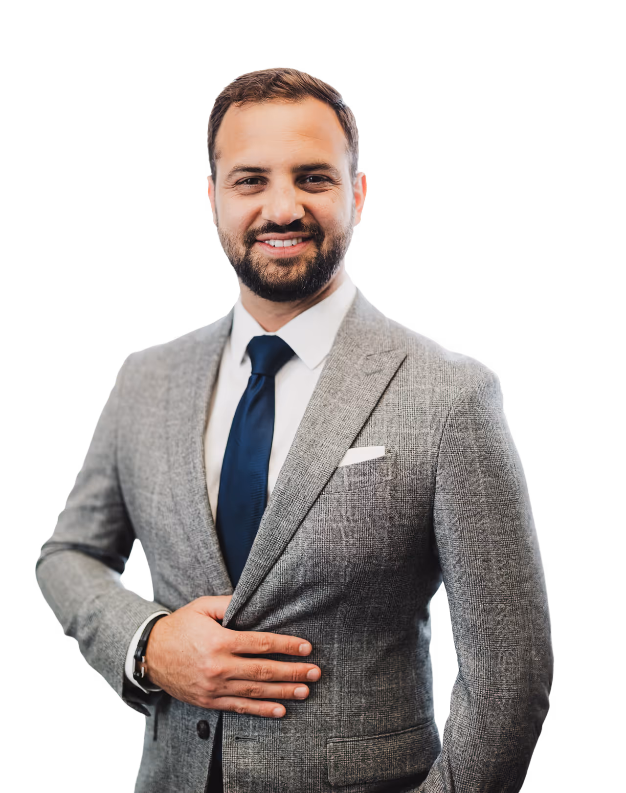 Smiling man in a gray suit jacket, white shirt, and dark blue tie, with hand holding the jacket front.
