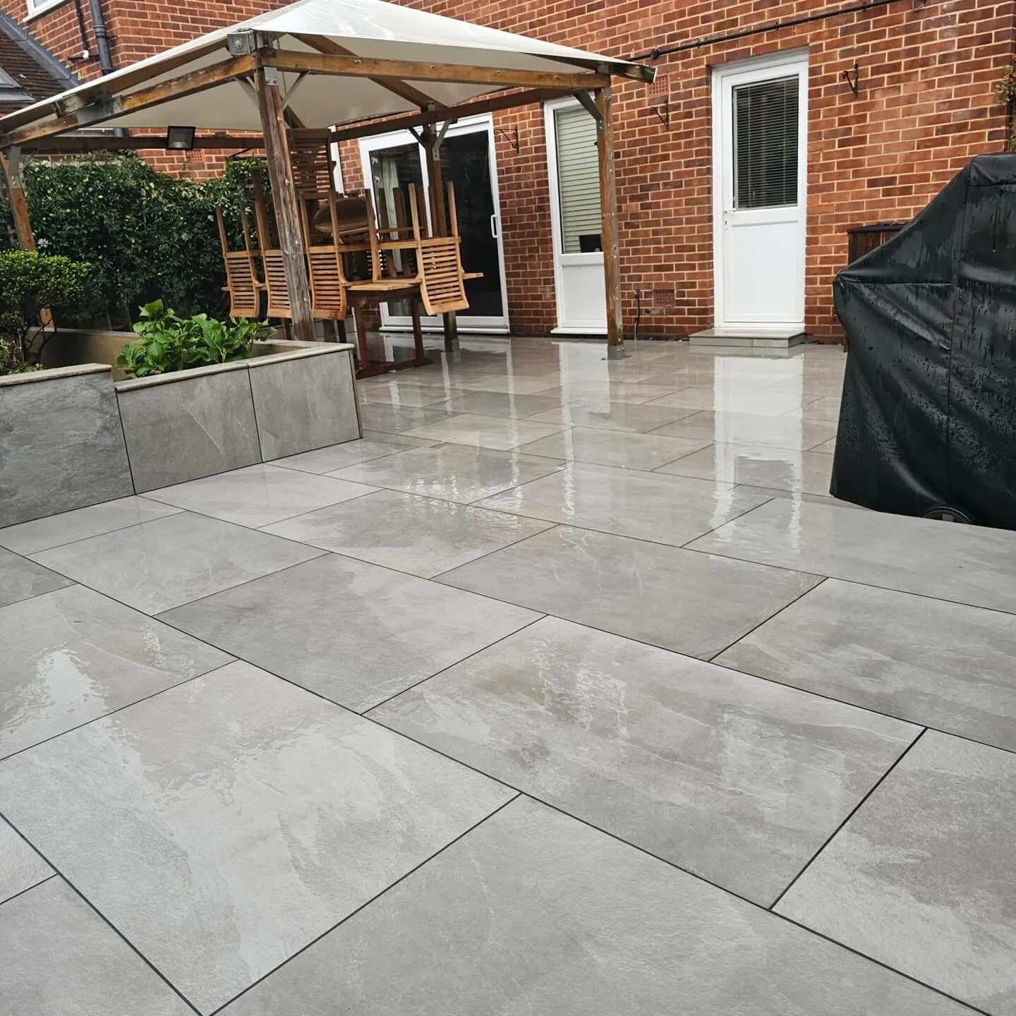 a patio with a covered patio and a brick building