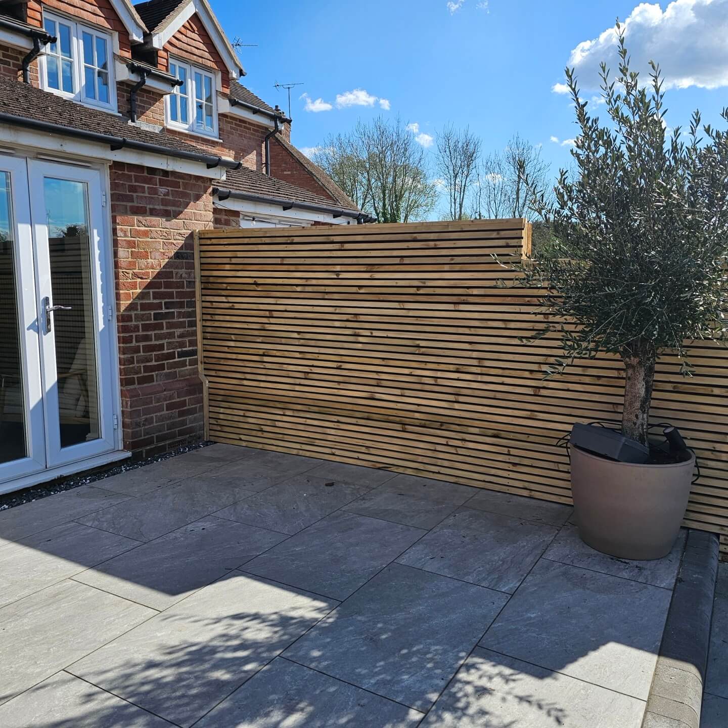 a stone patio with a wooden fence