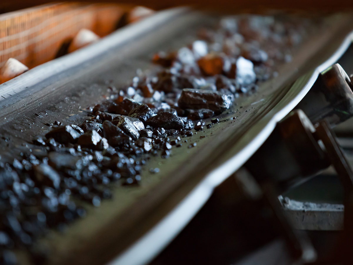 Ore on a conveyor belt, representing mining and resources litigation investigations