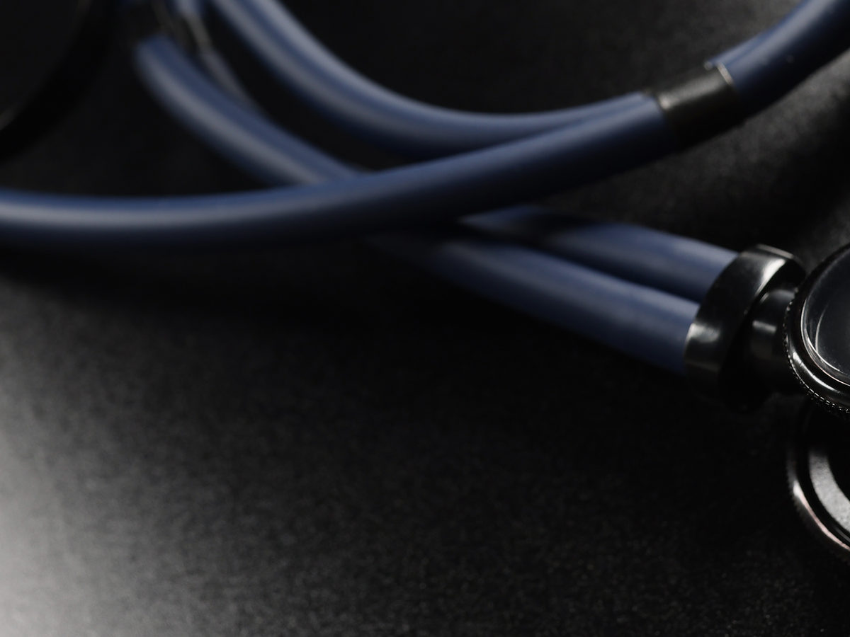 Stethoscope coiled on a dark surface, representing healthcare litigation investigations