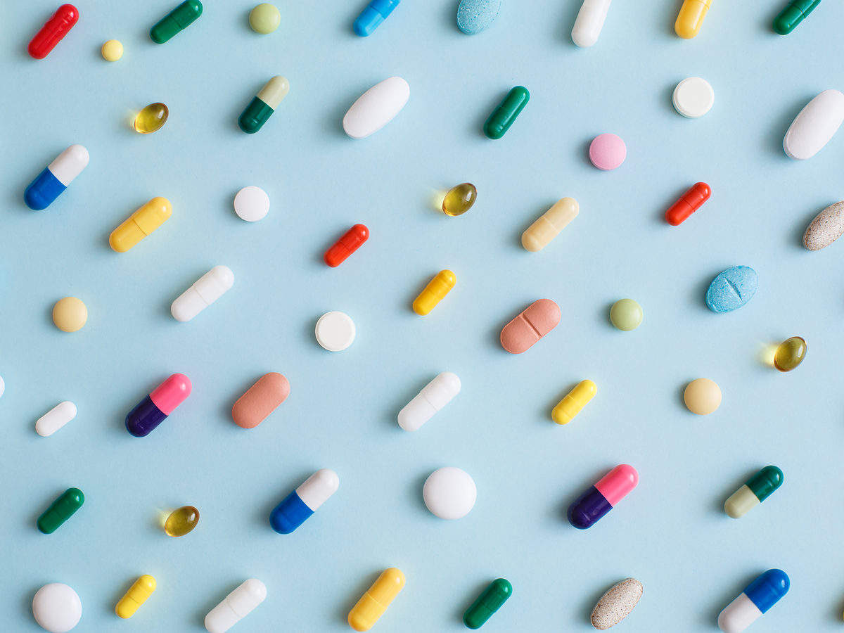 Pills and capsules laid out on a plain surface, representing pharmaceutical litigation investigations