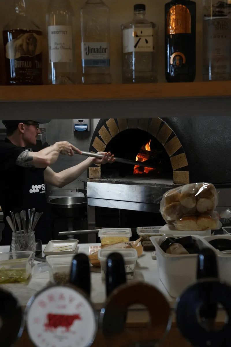 $30,000 Wood-Fired Pizza Oven - Staff taking pizza out