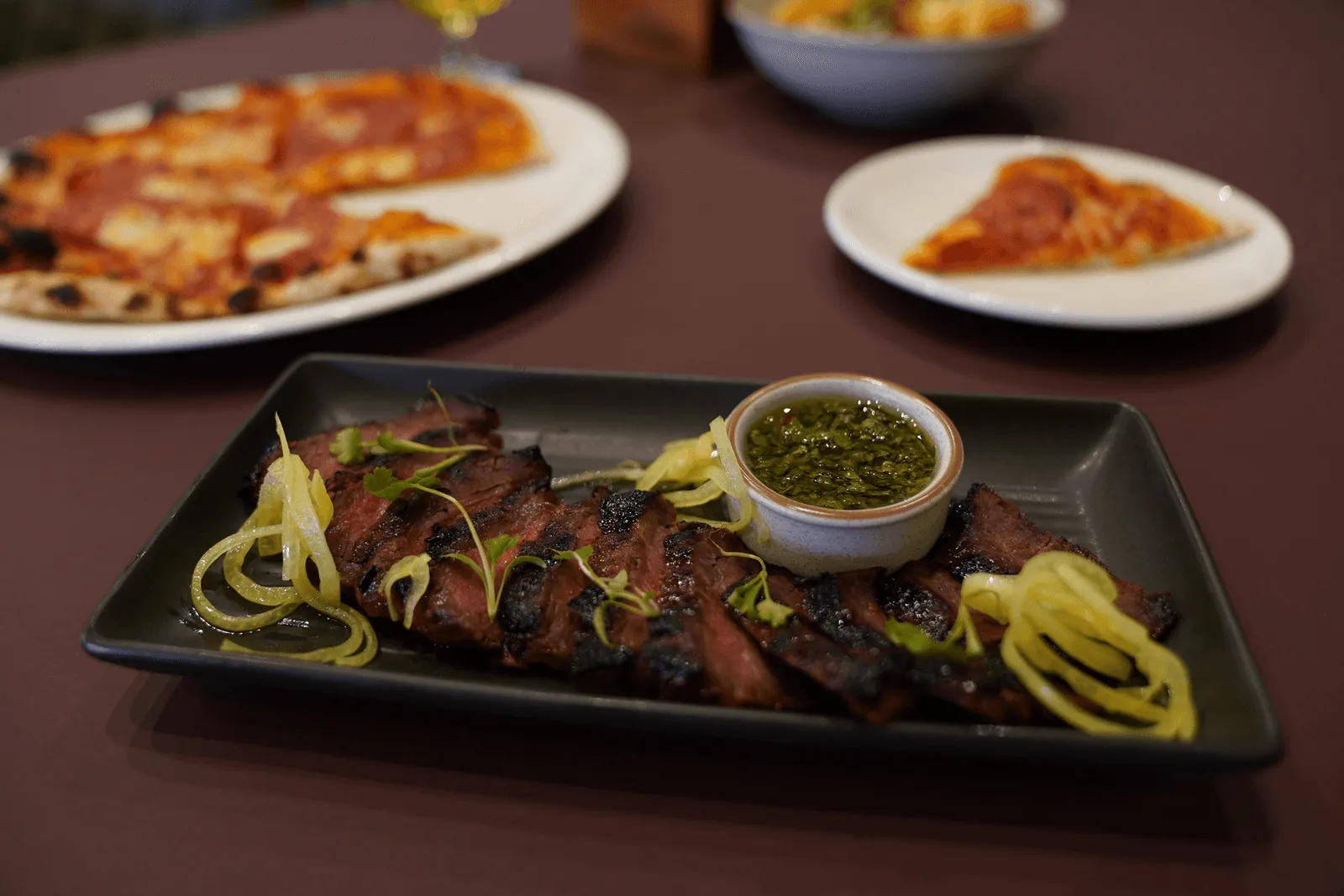 Thai-Canadian Flank Steak w/Zesty Dripping Sauce and Pizzas in the background