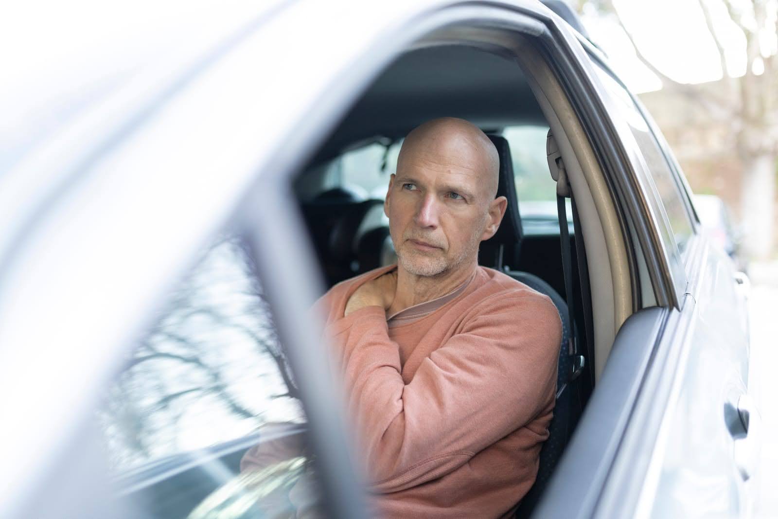 Man experiencing shoulder discomfort while driving