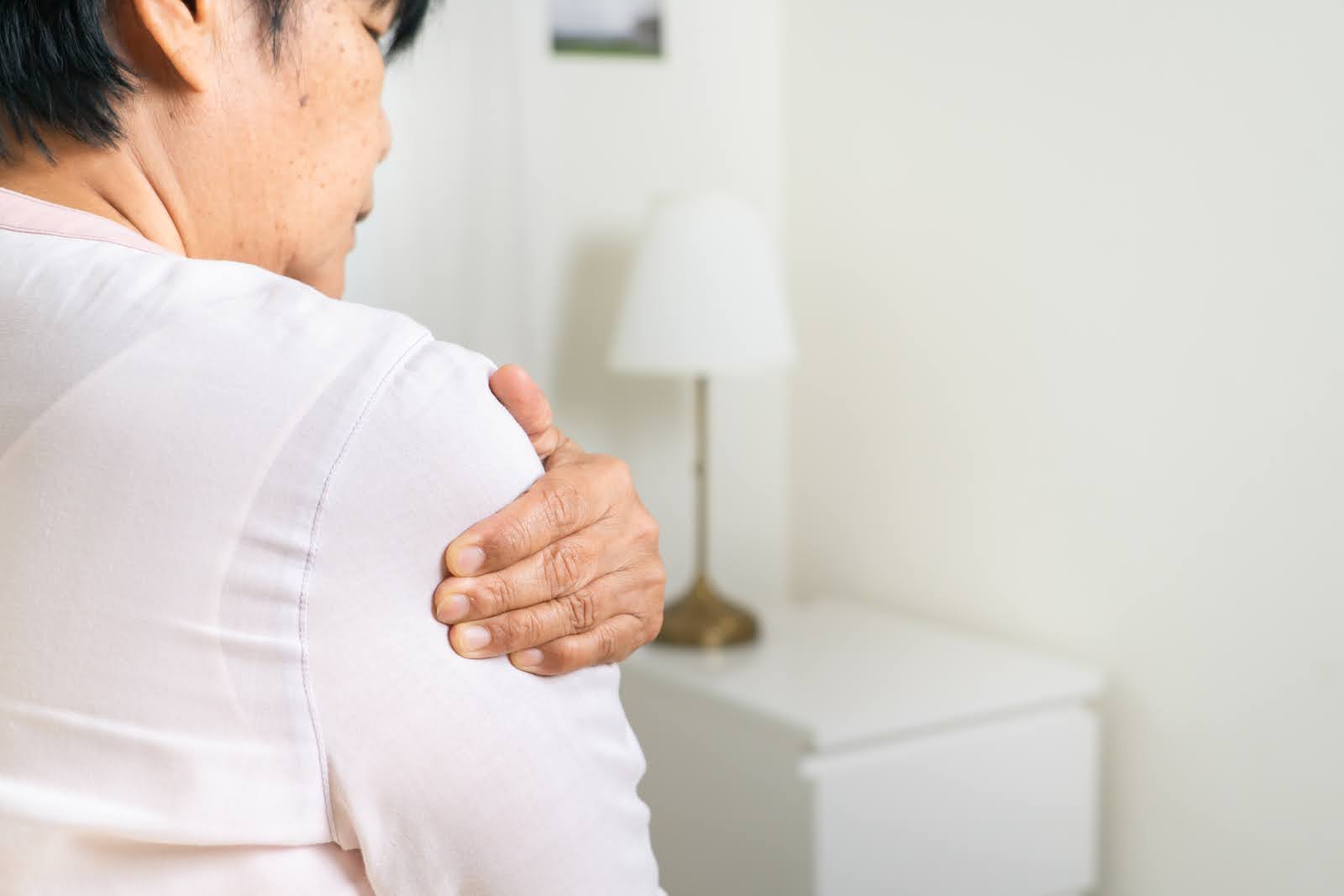 Senior woman experiencing chronic shoulder pain requiring orthopaedic treatment