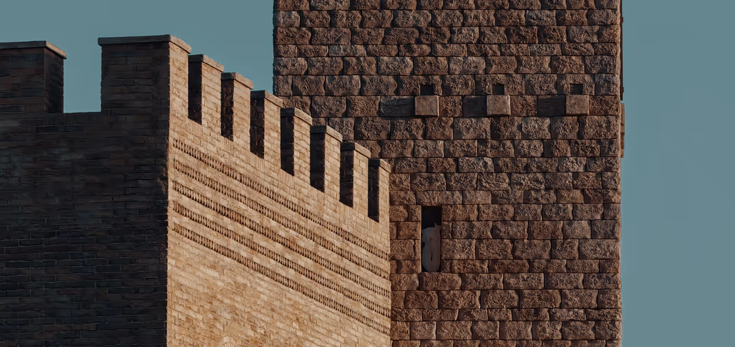 Close-up view of historic stone fortress walls and towers against a clear sky.