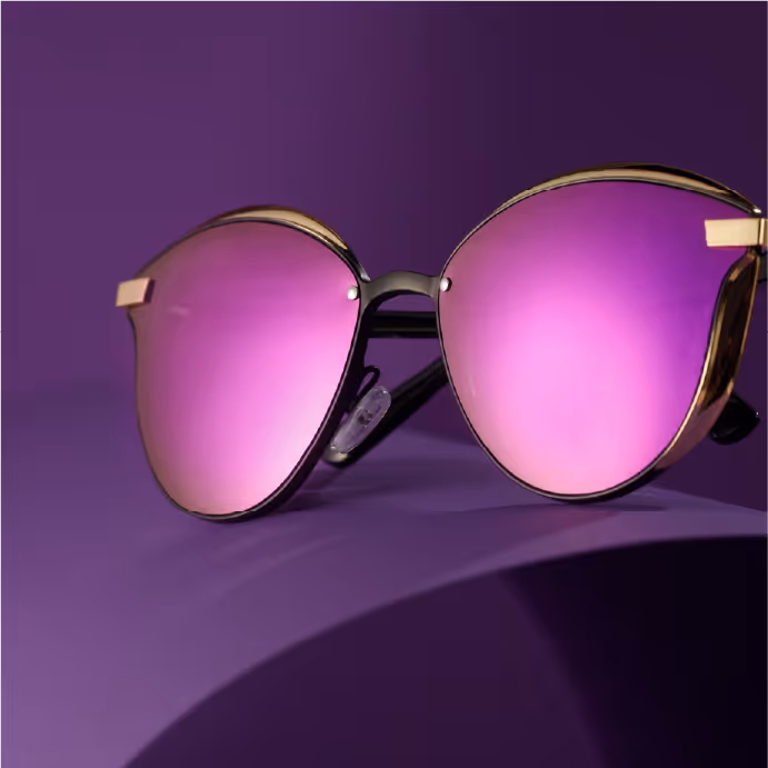 Stylish round sunglasses with purple mirrored lenses and gold frames on a purple background.
