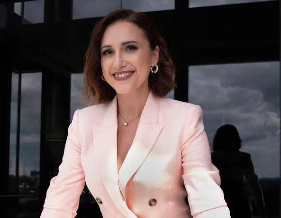 Emilia Bolda mit den Armen aufgestützt in hellem Blazer