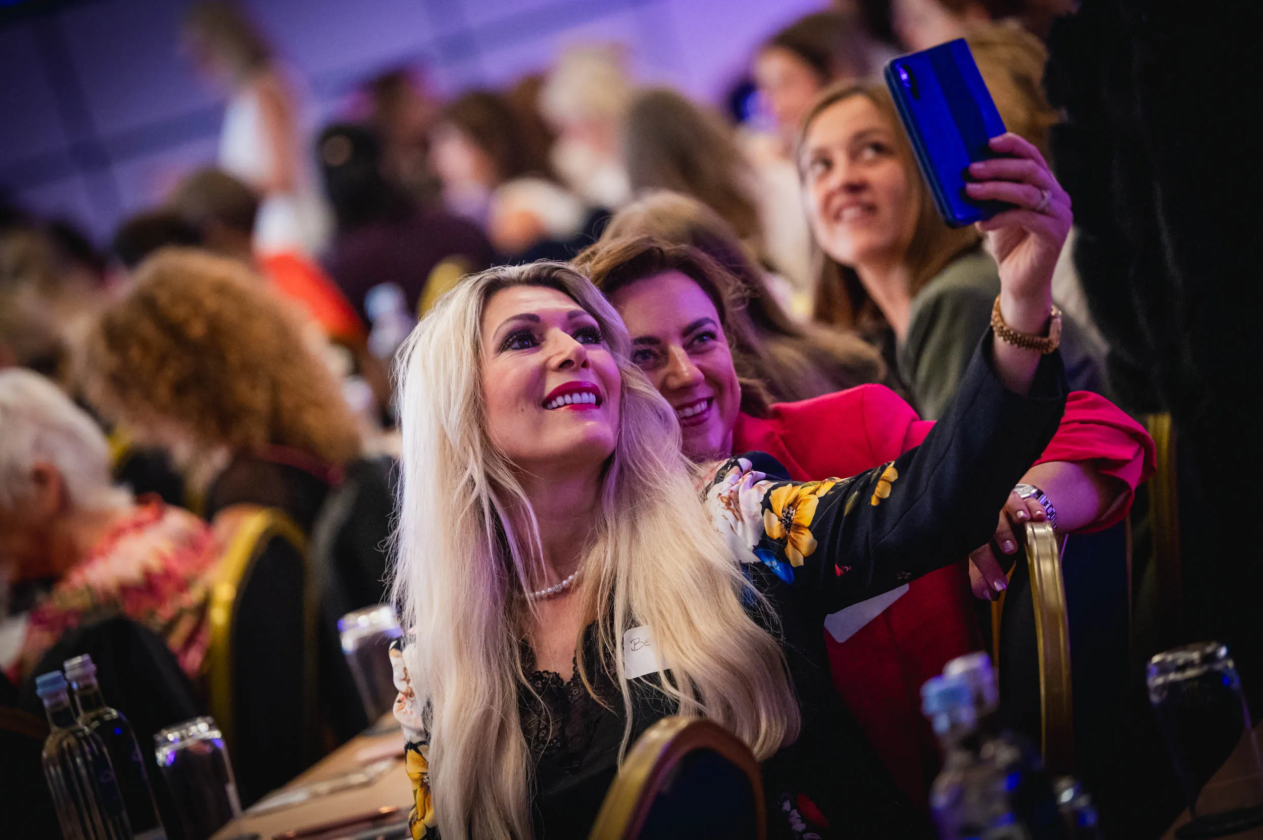 Eine Gruppe junger Frauen, die beim Investiere Dich Frei Summit im Publikum stehen und applaudieren