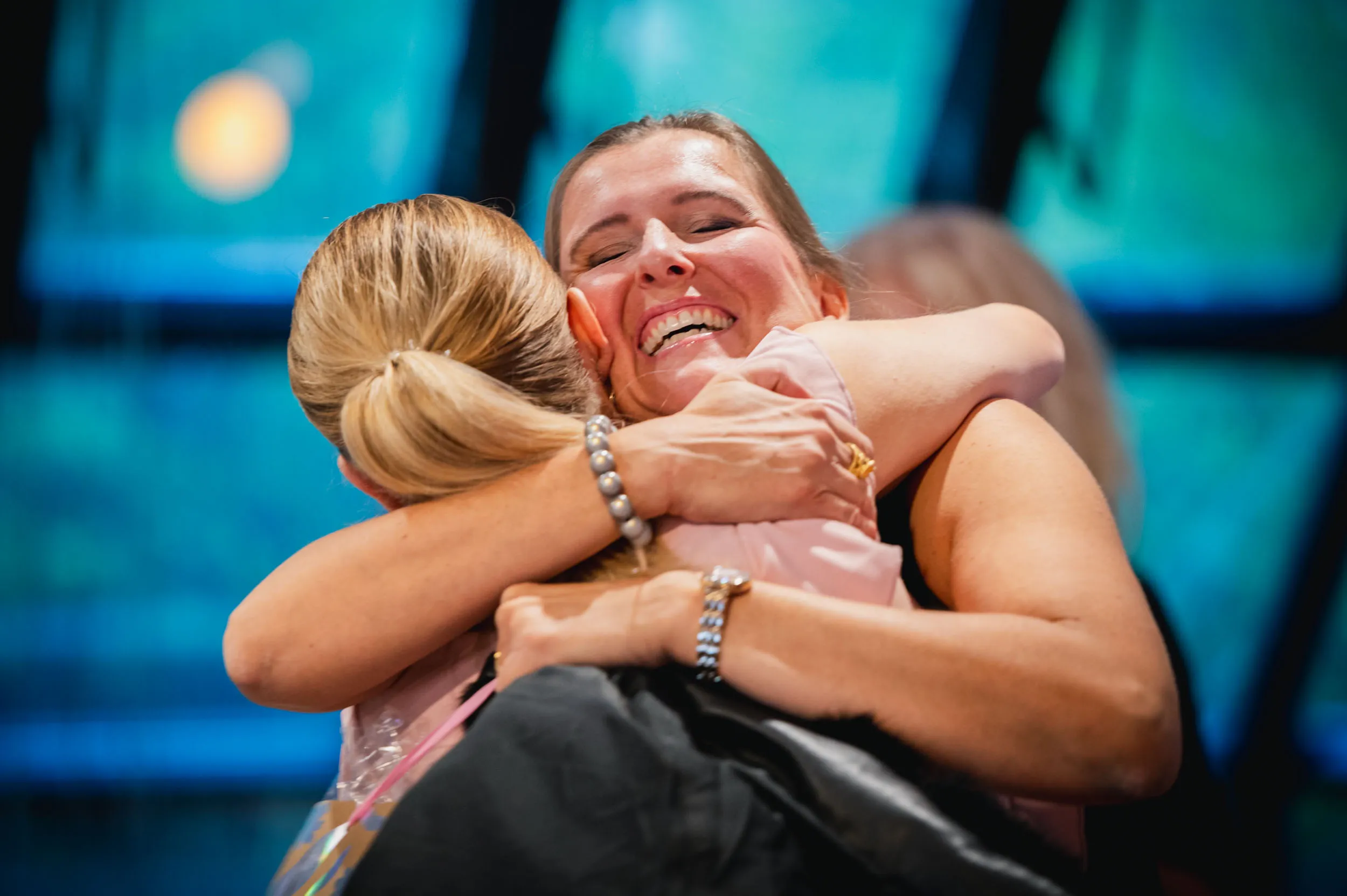 Eine Gruppe junger Frauen, die beim Investiere Dich Frei Summit im Publikum stehen und applaudieren