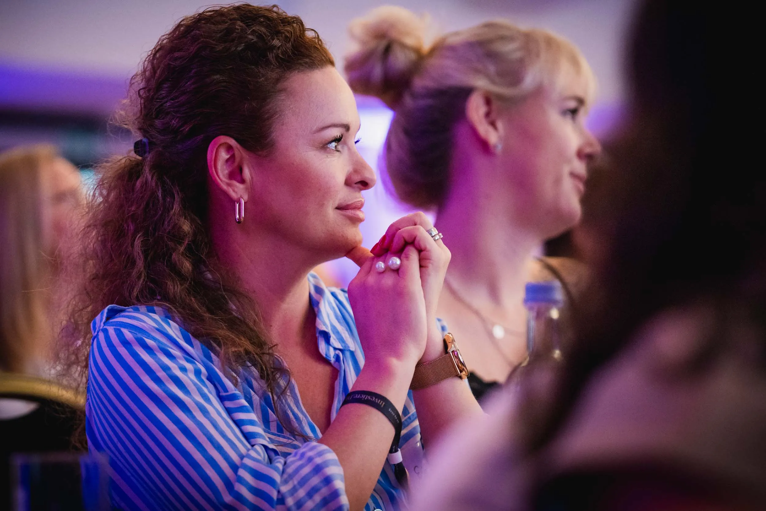 Eine Gruppe junger Frauen, die beim Investiere Dich Frei Summit im Publikum stehen und applaudieren