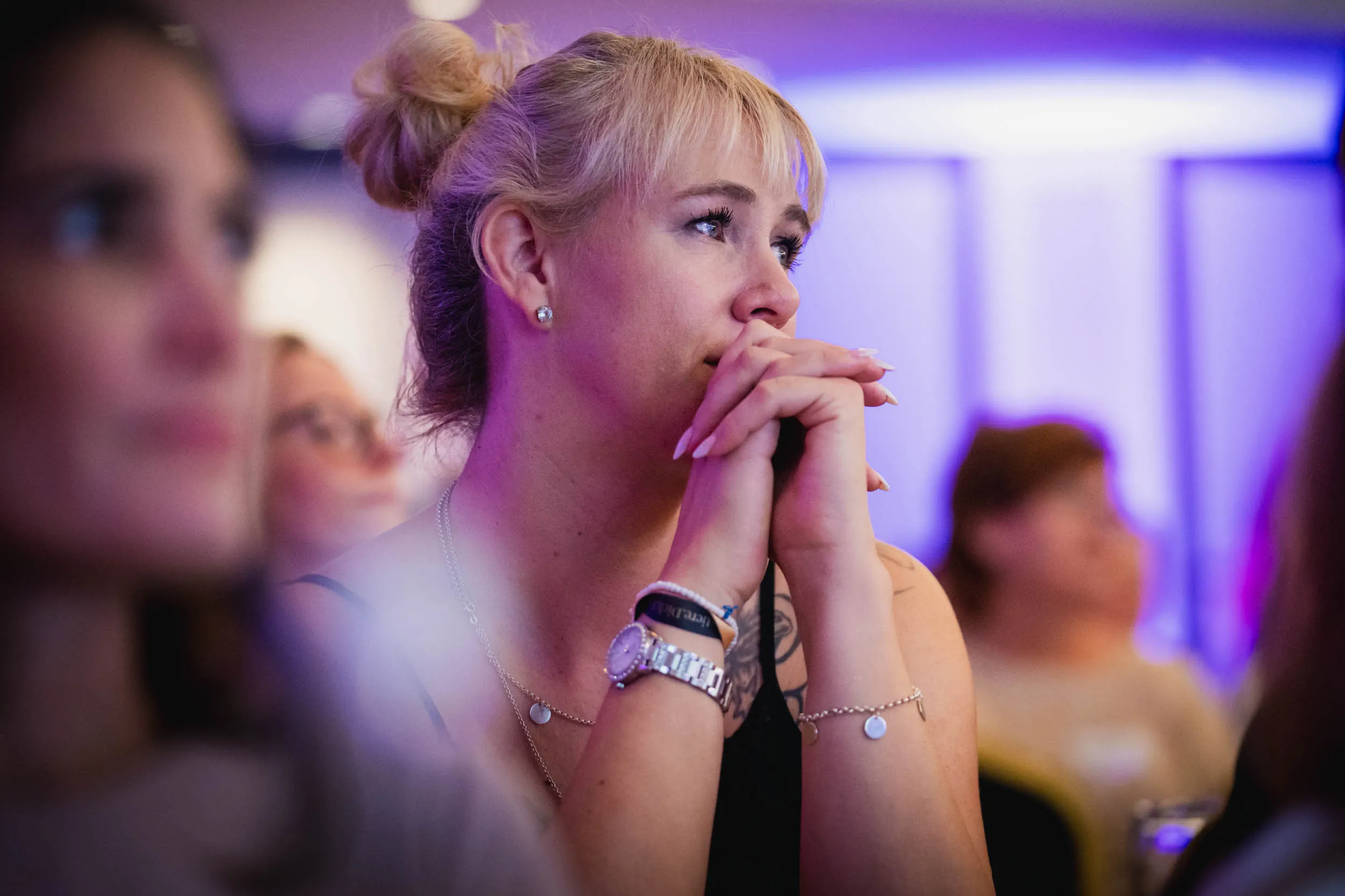 Eine Gruppe junger Frauen, die beim Investiere Dich Frei Summit im Publikum stehen und applaudieren
