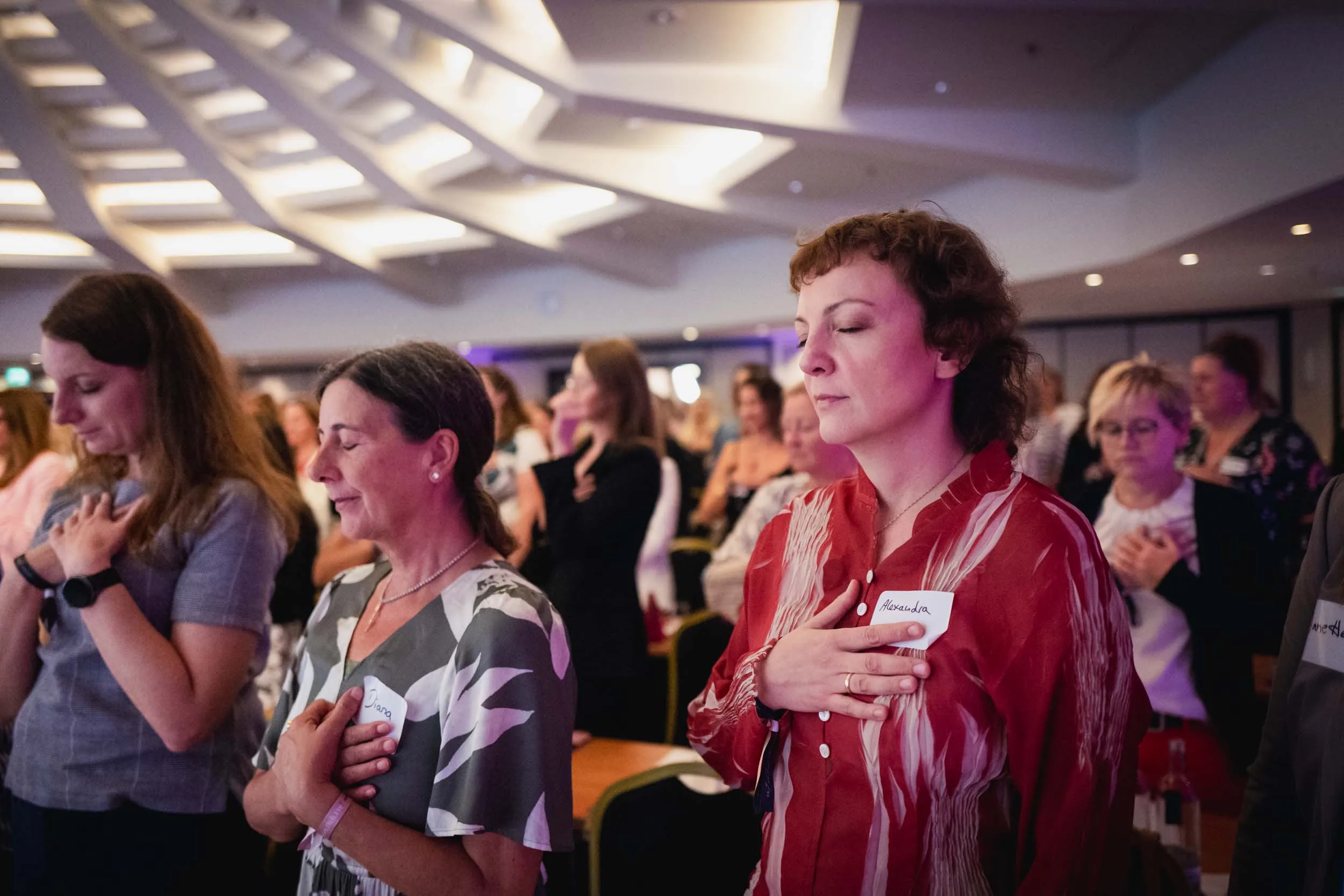 Eine Gruppe junger Frauen, die beim Investiere Dich Frei Summit im Publikum stehen und applaudieren