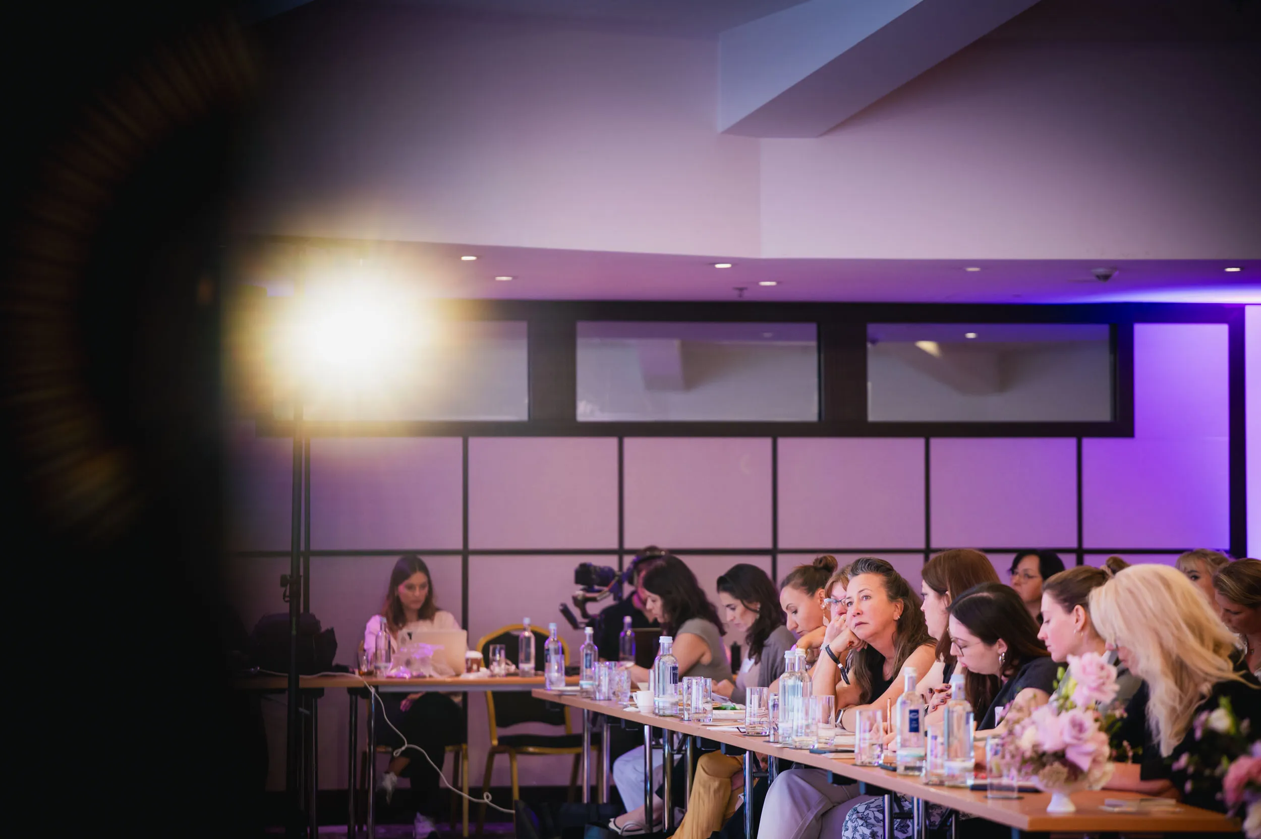 Eine Gruppe junger Frauen, die beim Investiere Dich Frei Summit im Publikum stehen und applaudieren