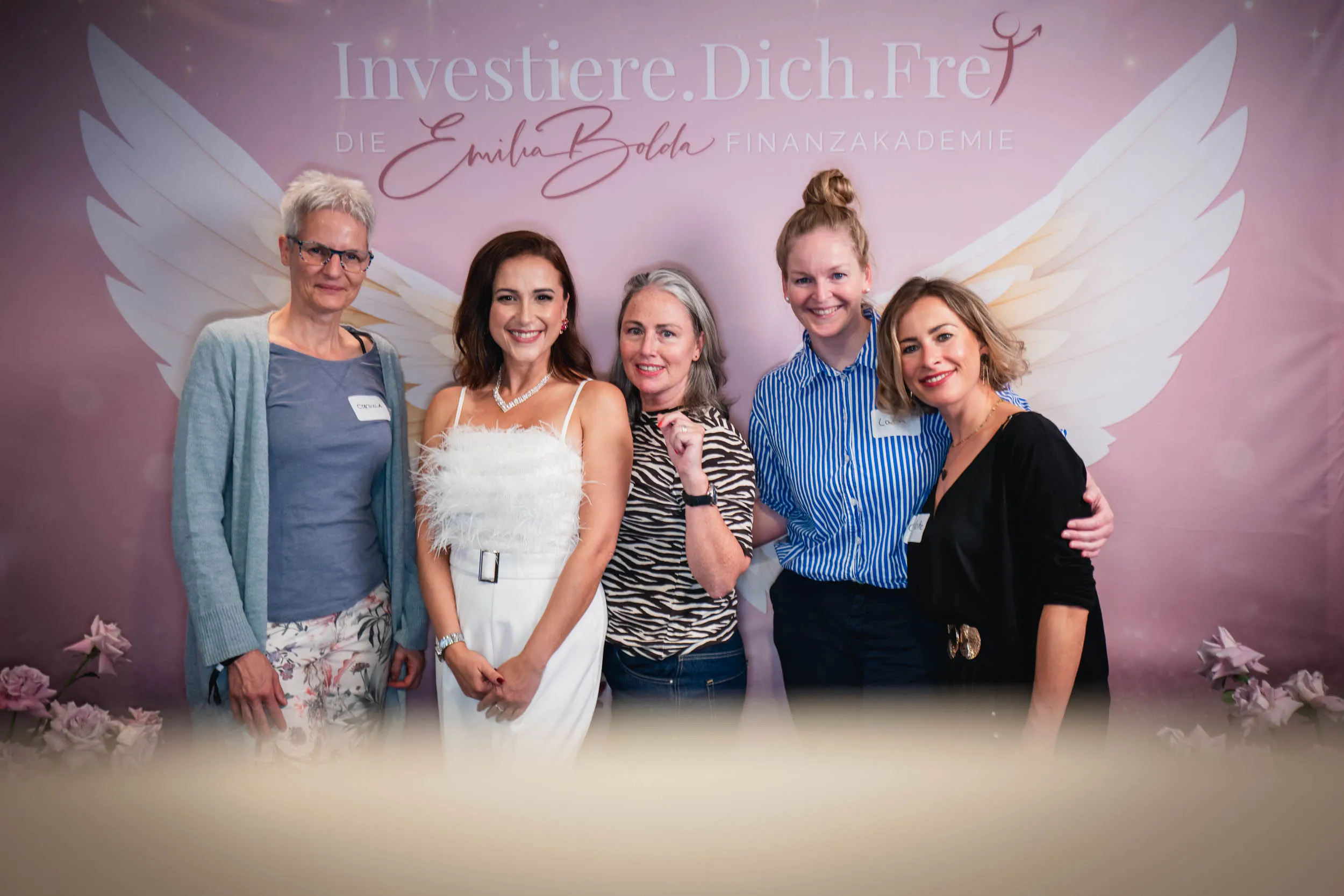Eine Gruppe junger Frauen, die beim Investiere Dich Frei Summit im Publikum stehen und applaudieren