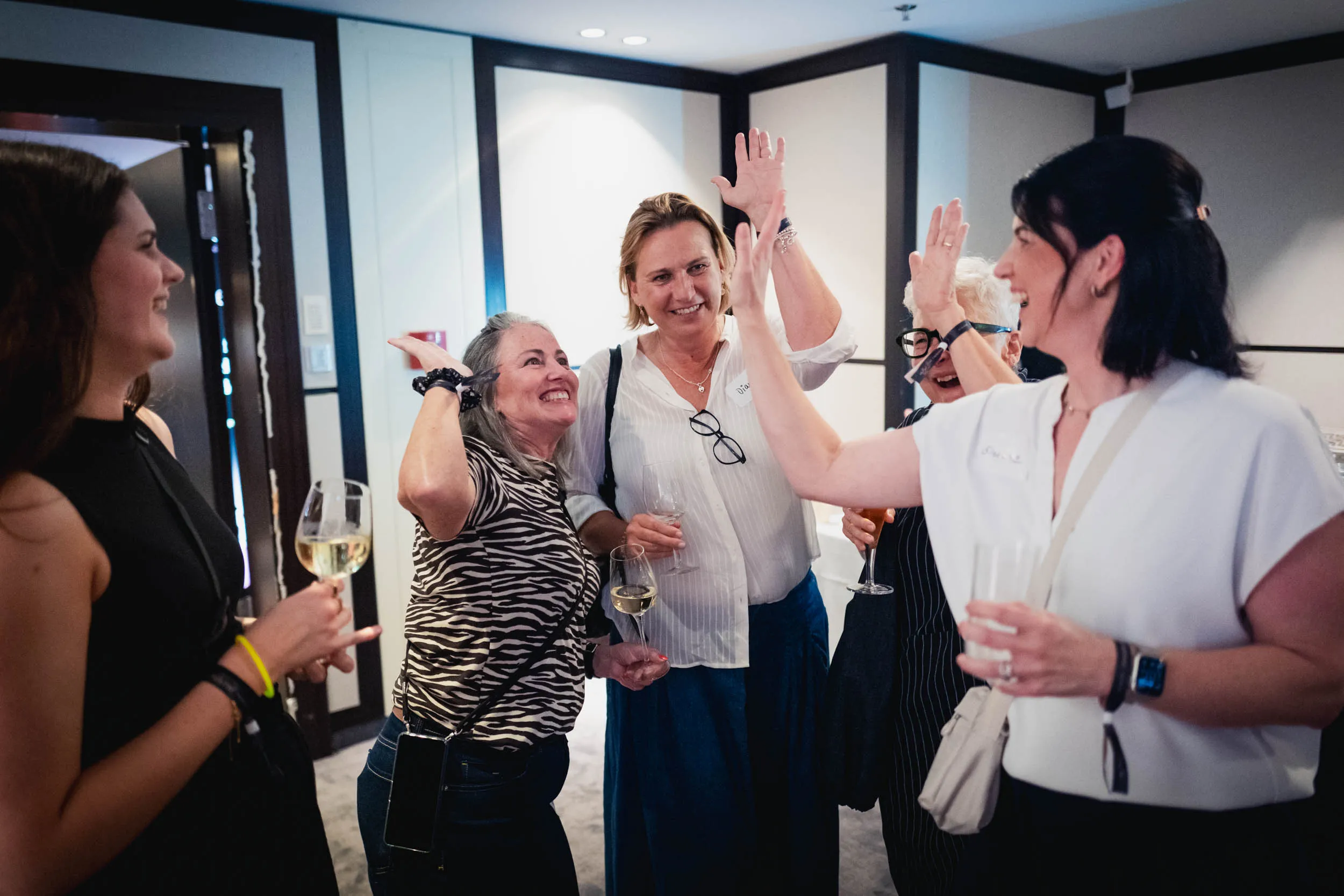 Eine Gruppe junger Frauen, die beim Investiere Dich Frei Summit im Publikum stehen und applaudieren