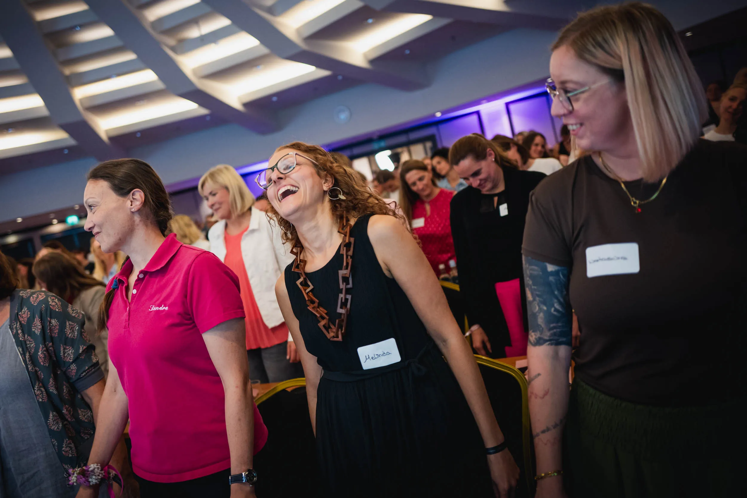 Eine Gruppe junger Frauen, die beim Investiere Dich Frei Summit im Publikum stehen und applaudieren