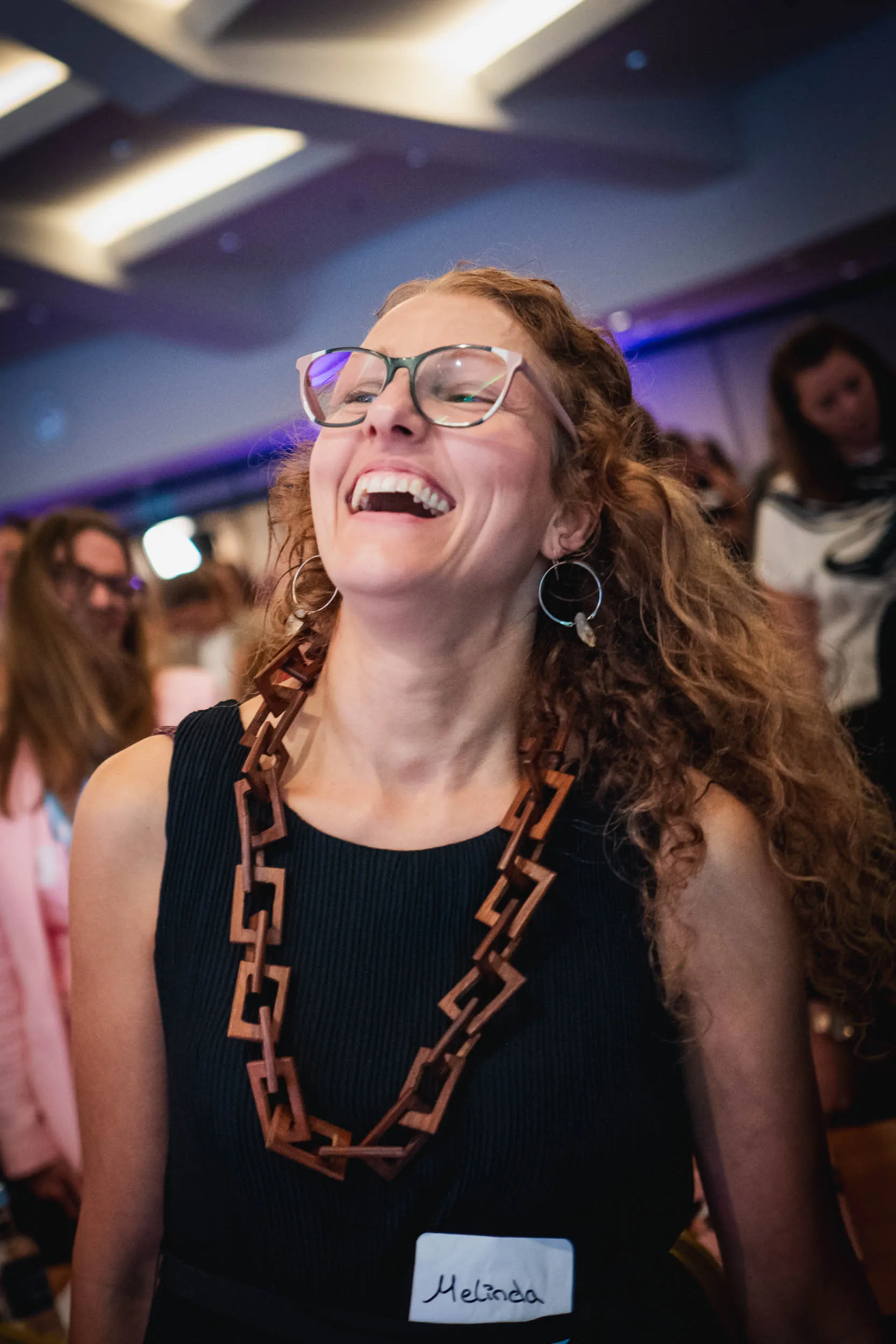 Eine Gruppe junger Frauen, die beim Investiere Dich Frei Summit im Publikum stehen und applaudieren