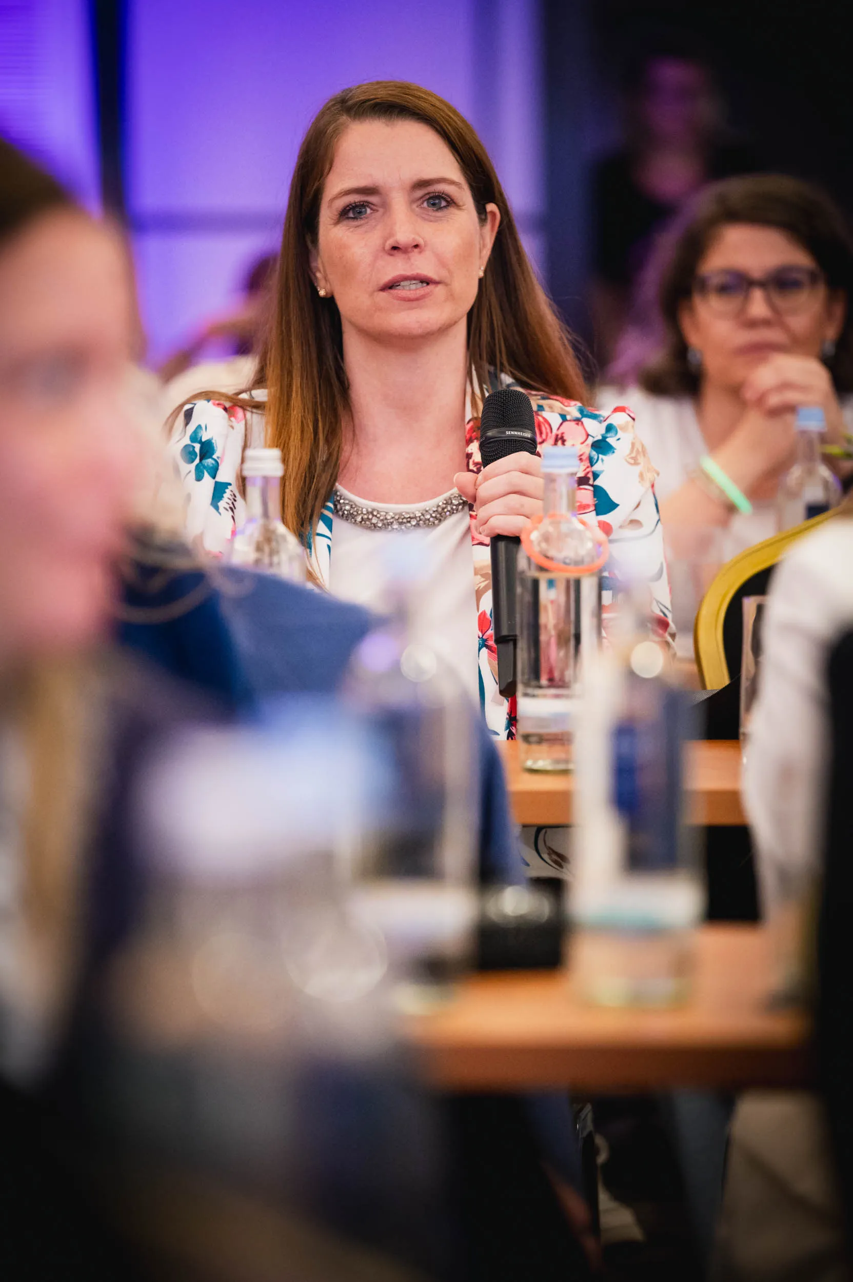 Eine Gruppe junger Frauen, die beim Investiere Dich Frei Summit im Publikum stehen und applaudieren
