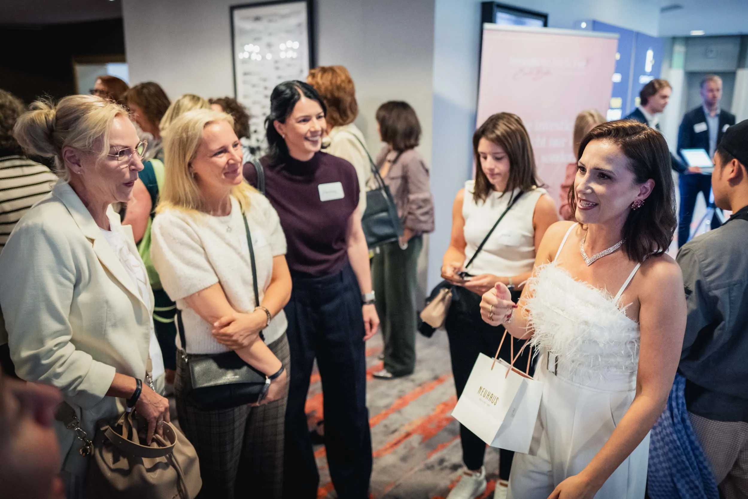 Eine Gruppe junger Frauen, die beim Investiere Dich Frei Summit im Publikum stehen und applaudieren