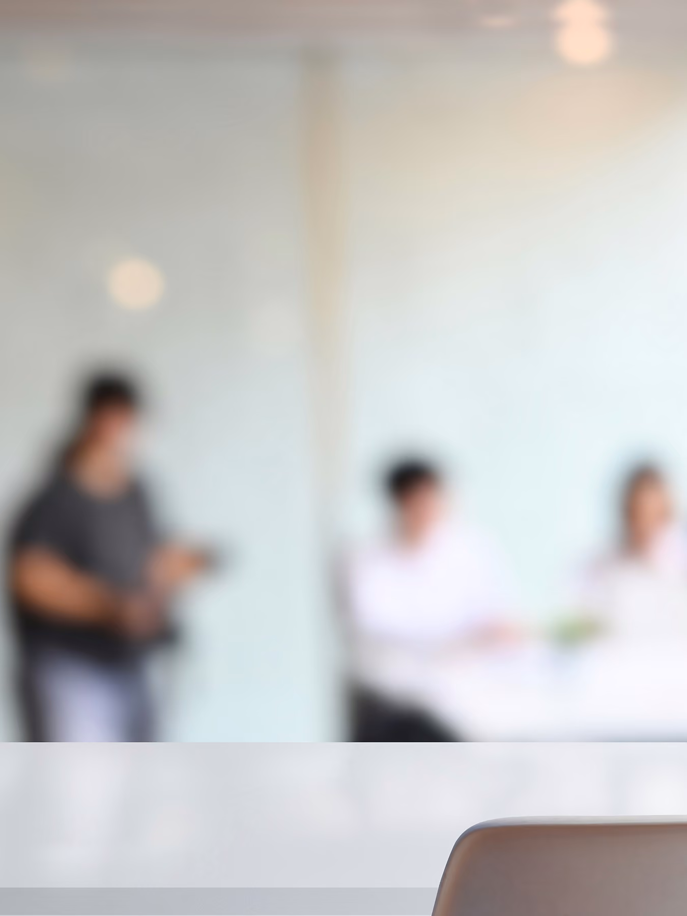 Blurred office scene with a chair in focus in the foreground.