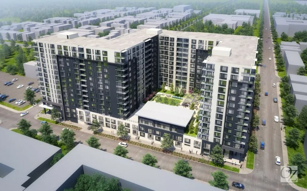 Aerial view of a modern U-shaped apartment complex with multiple stories, balconies, and a central courtyard featuring greenery.