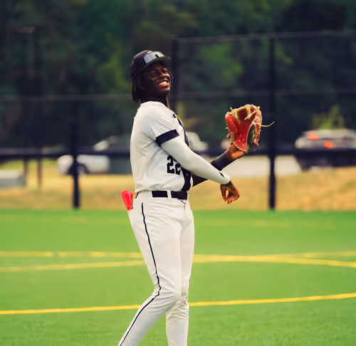 Baseball player throwing baseball smiling