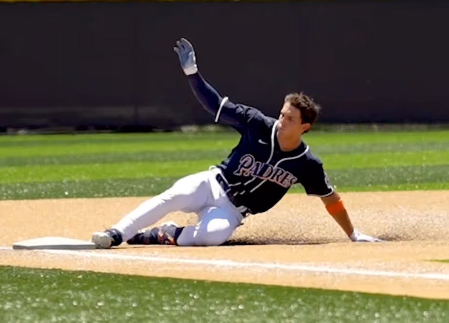 Baseball player sliding into a plate.