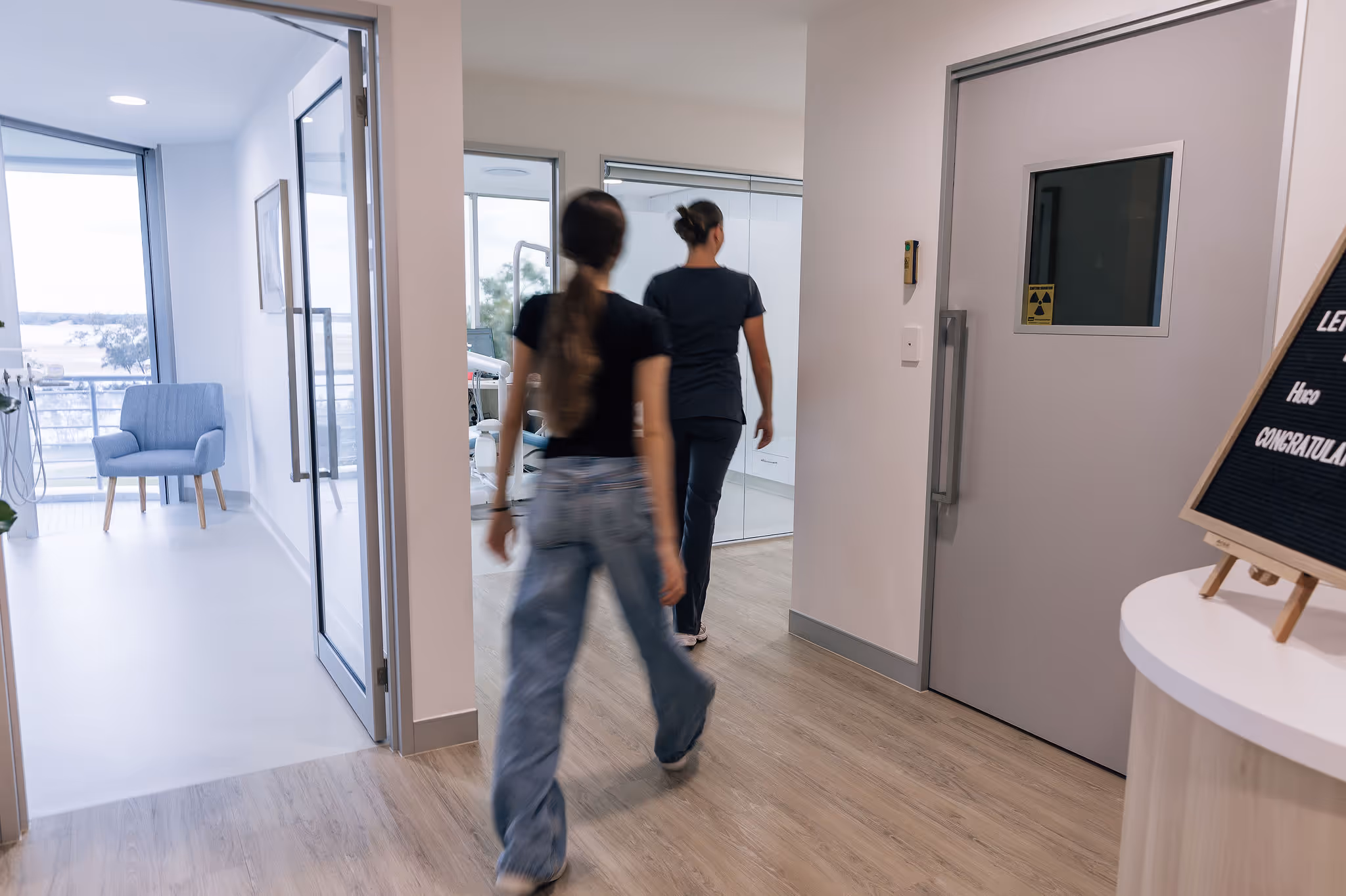 Two people walking into a dentists surgery.