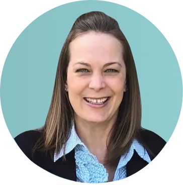 Portrait of a smiling woman with brown hair wearing a black blazer and light blue ruffled blouse.