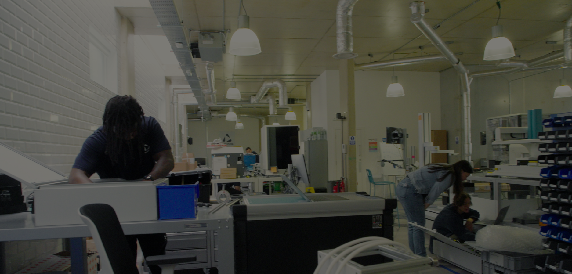 People working in a modern industrial workshop with machinery and equipment.