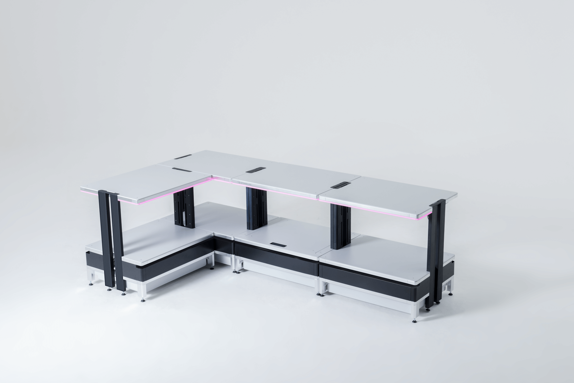 Modern modular L-shaped workstation with white surfaces, black vertical supports, and pink LED lighting accents.
