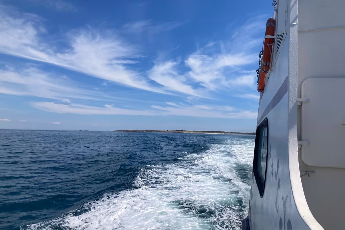 Bateau en traversée vers l’Île d’Yeu, sillage sur l’océan sous un ciel bleu — Festival Les Insulaires.