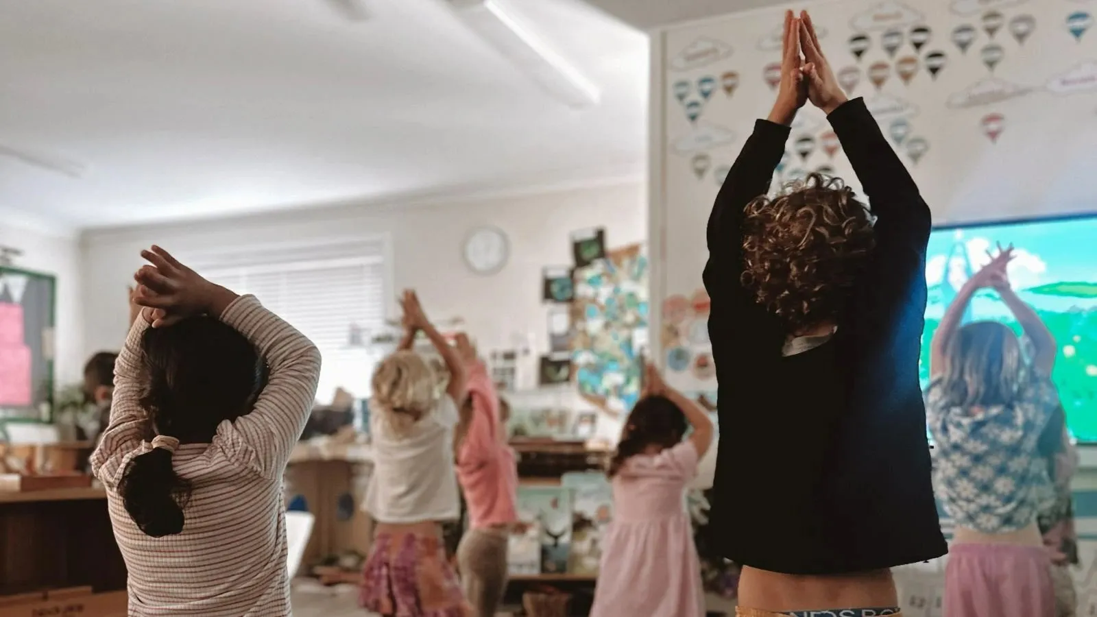 A group of children doing exercise in a classroom.