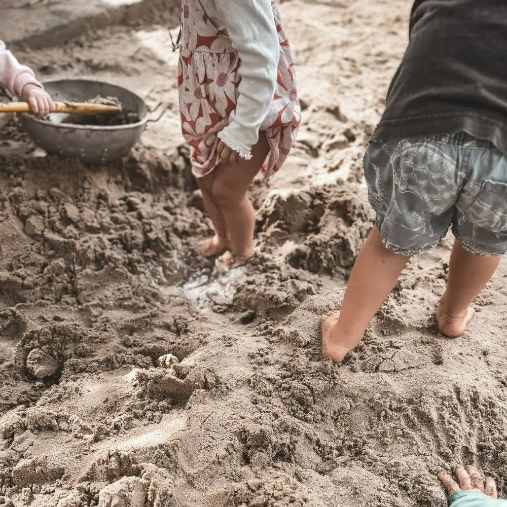 A group of children playing in the sand.