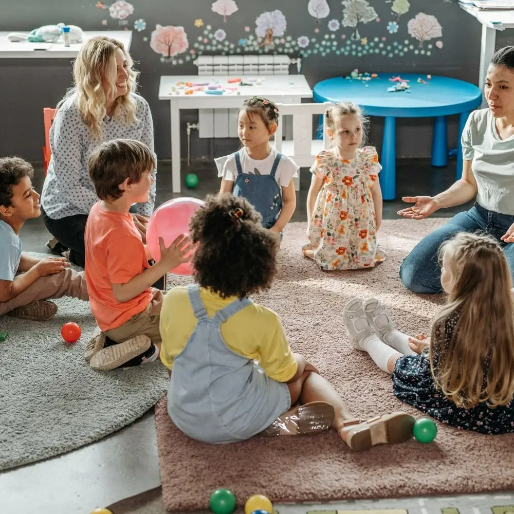 A group of children sitting on the floor in a room.