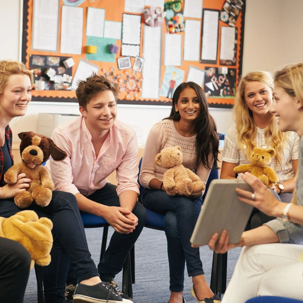 A group of people sitting in a room with stuffed animals.