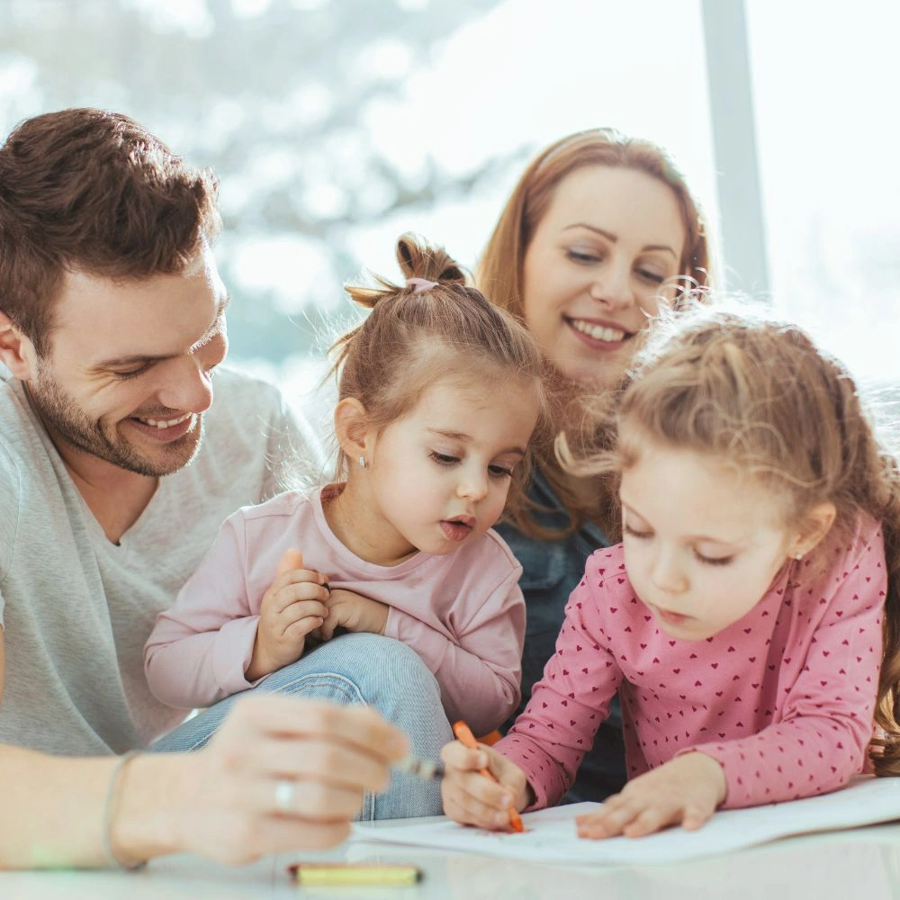 A man and two little girls sitting on a couch.