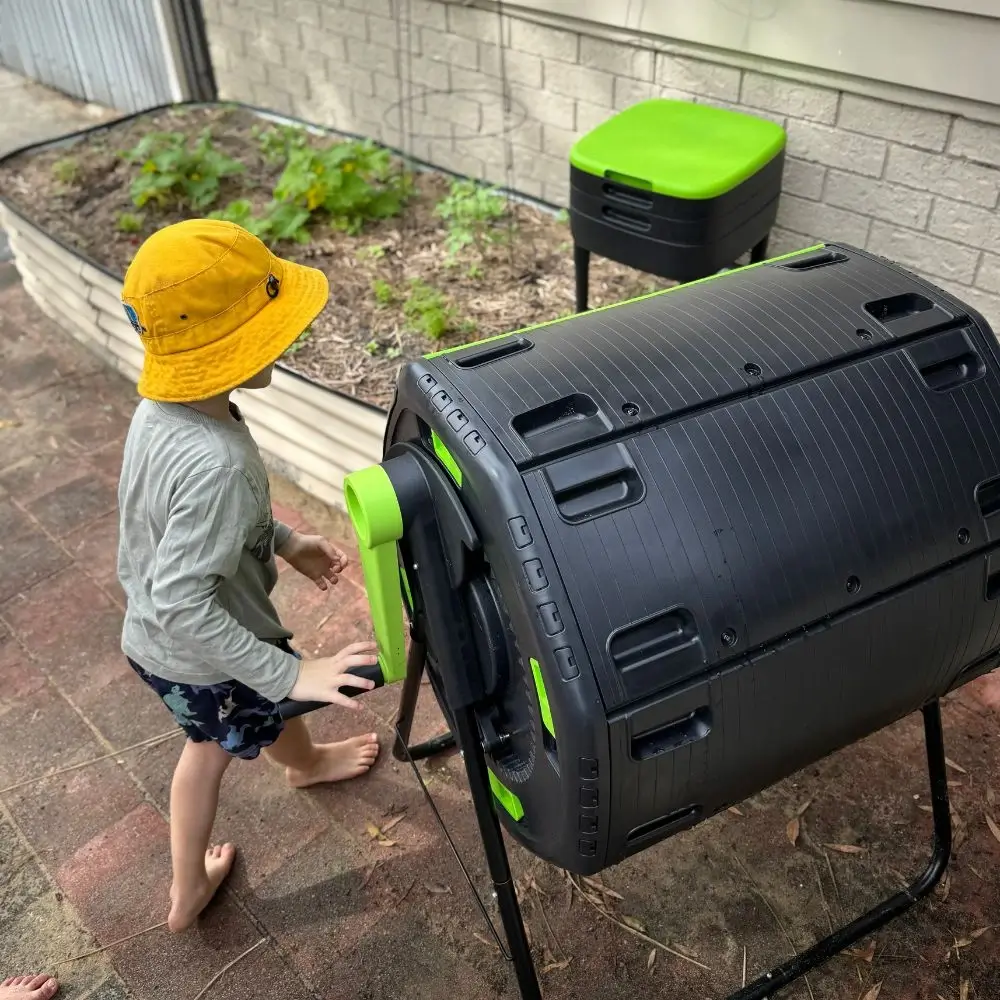 A young boy putting a green box into a black box.