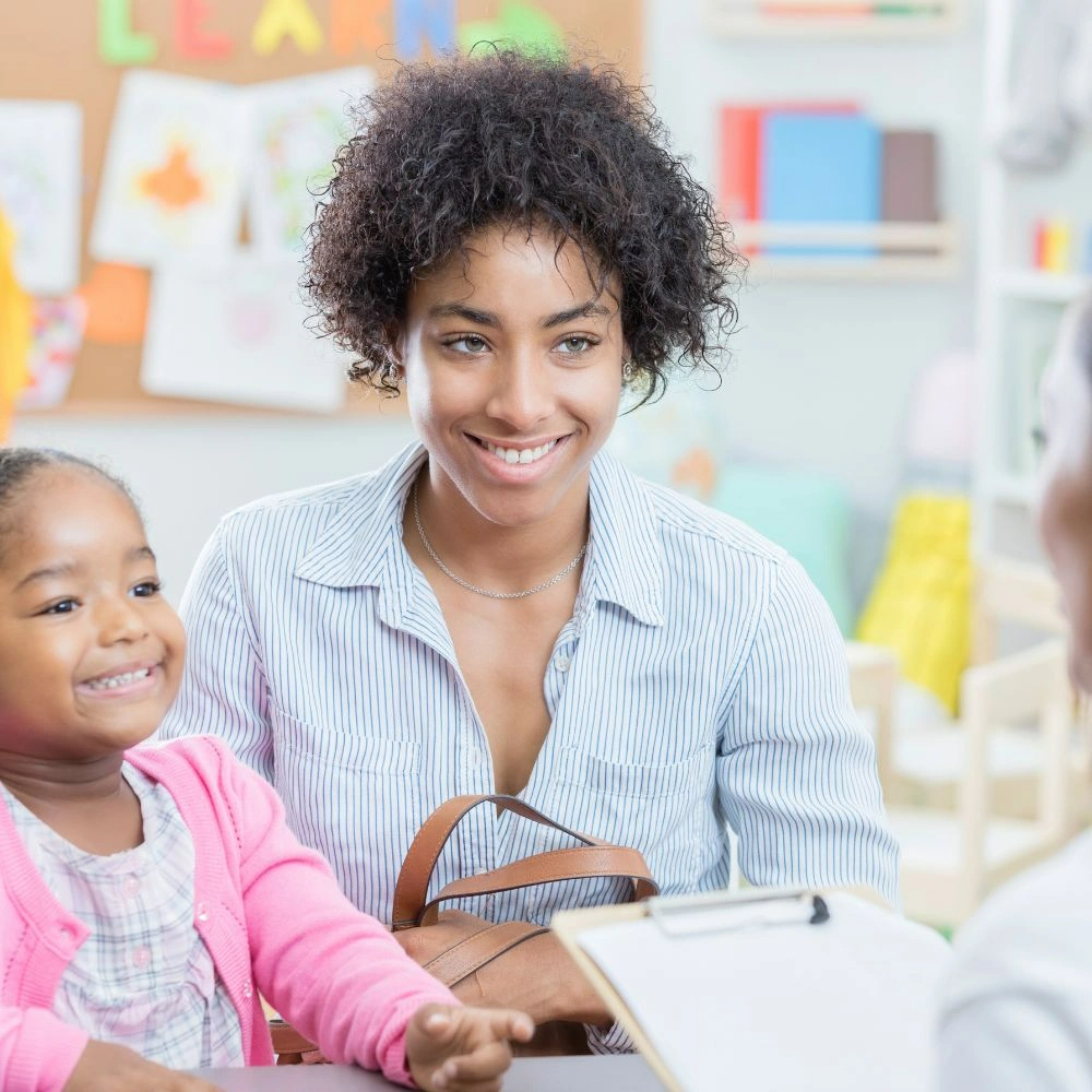 A woman sitting at a desk with a child.