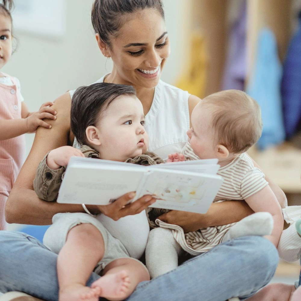 A woman reading a book to two children.