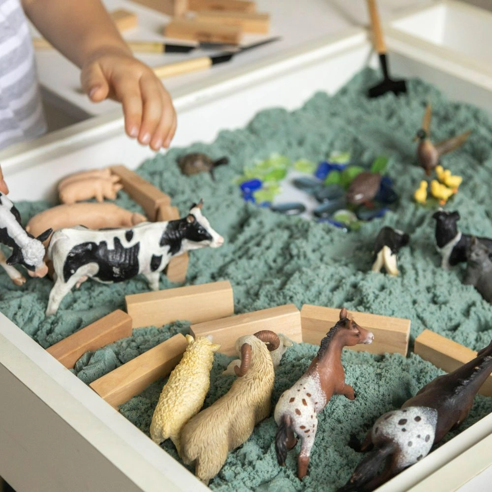 A child is playing with toys in a box.