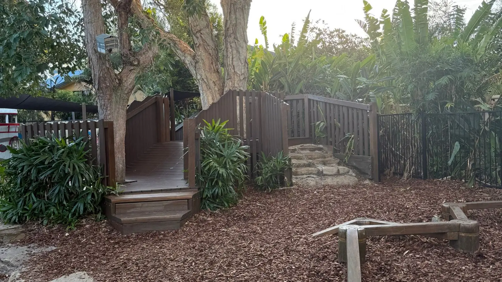 A wooden gate and steps in a garden.