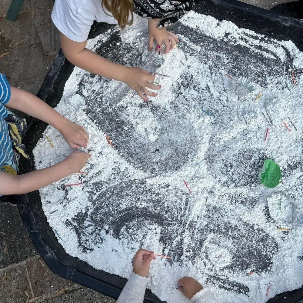 A couple of kids that are standing in front of a table.