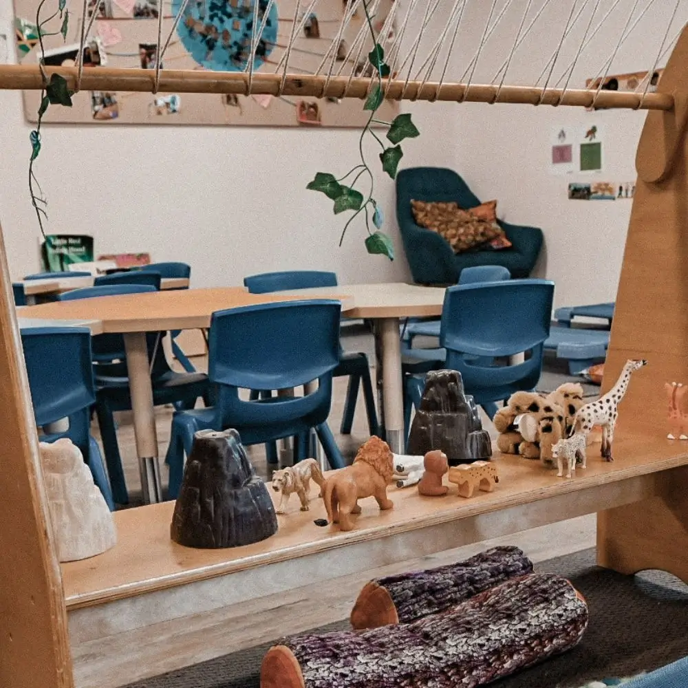 A room filled with blue chairs and wooden tables.